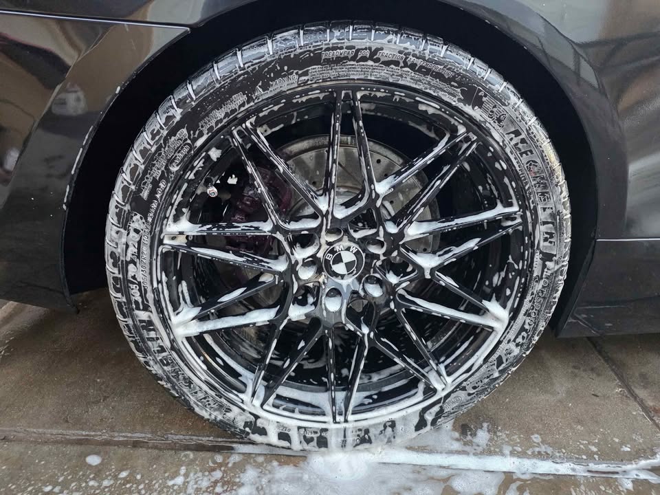 BMW wheel deep cleaned with foam during detail service